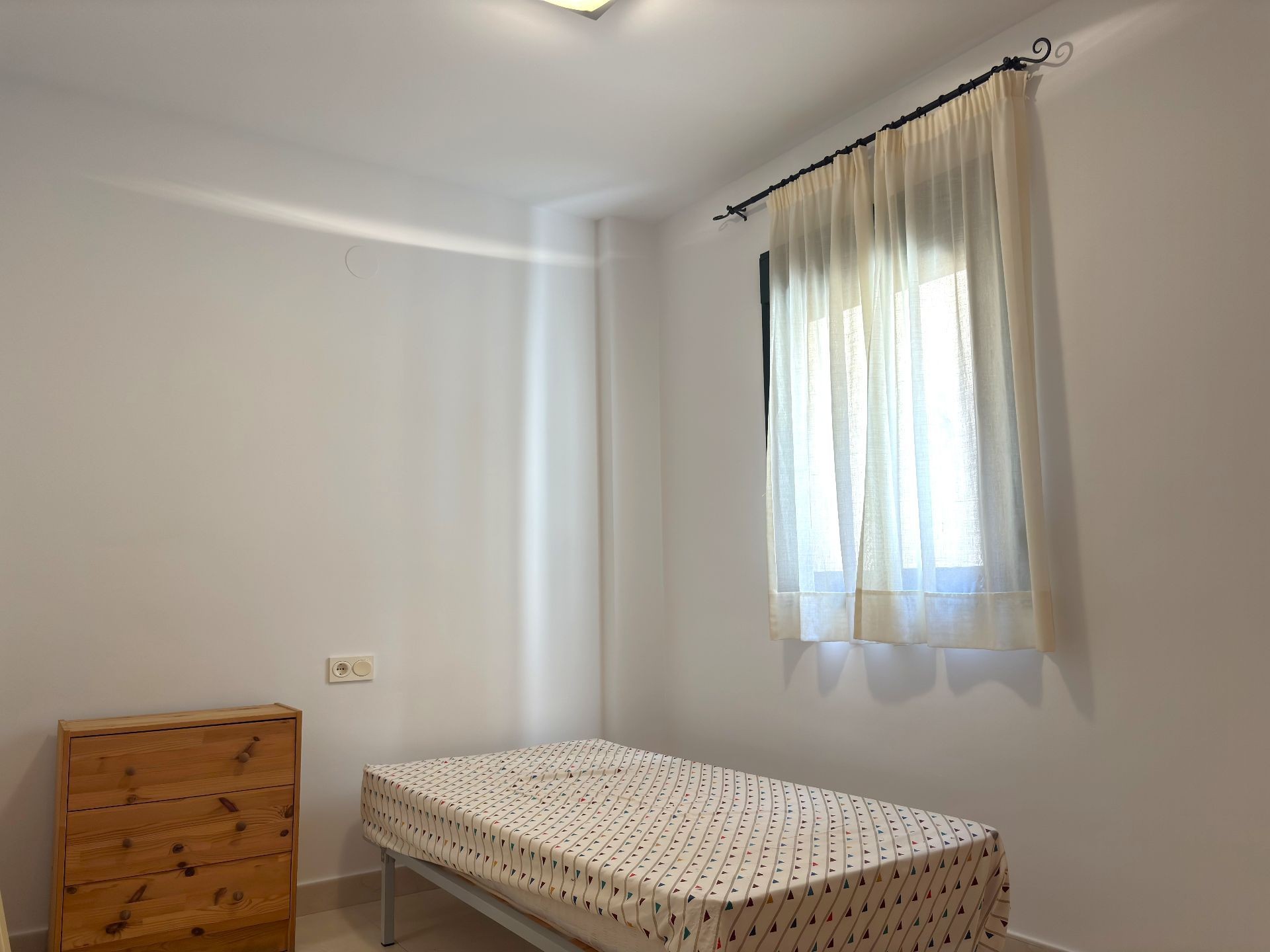 Small bedroom with single bed and window