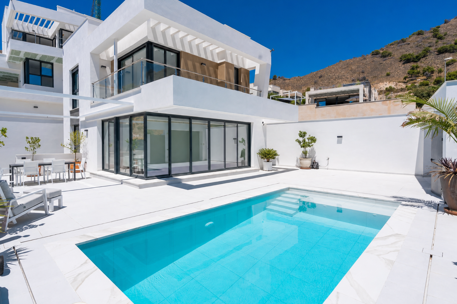 Outdoor pool with mountain backdrop and terrace