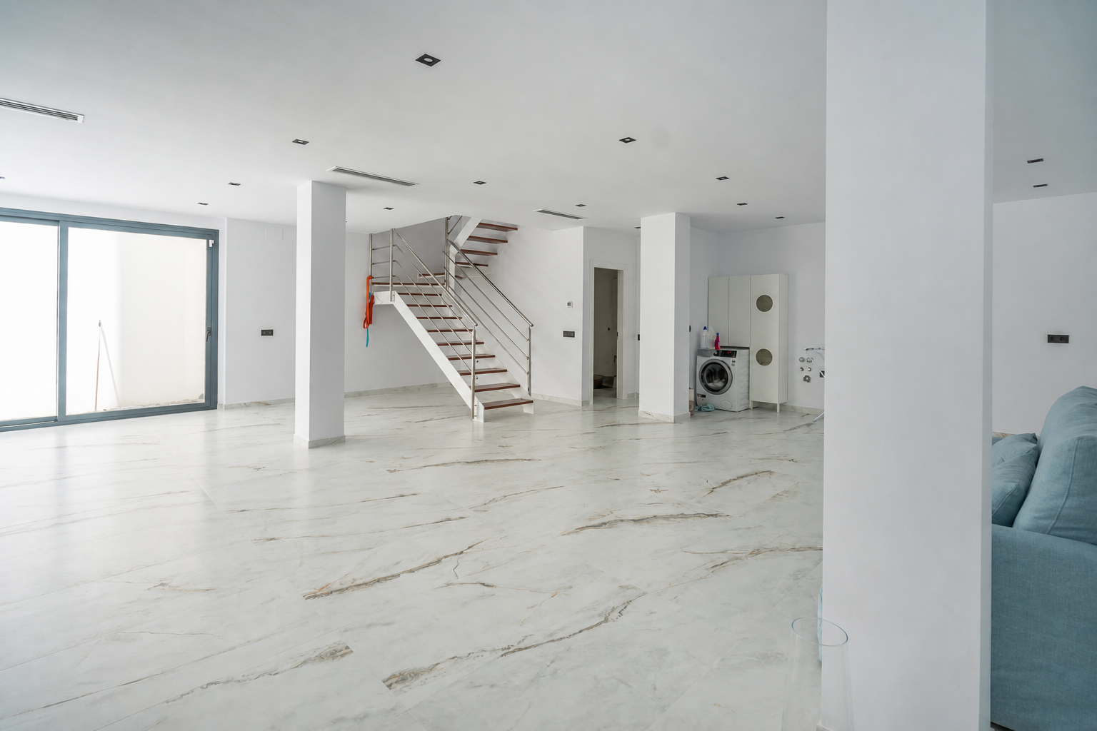 Large interior space with staircase and laundry area
