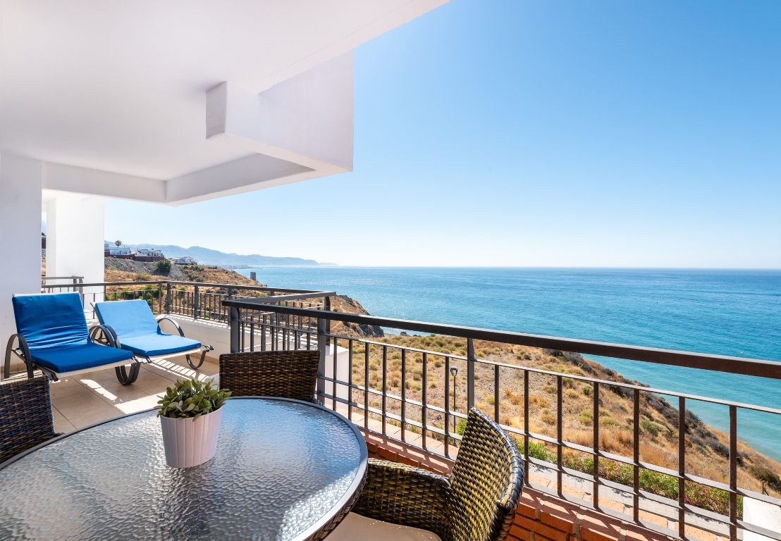 Covered terrace with table and sea views