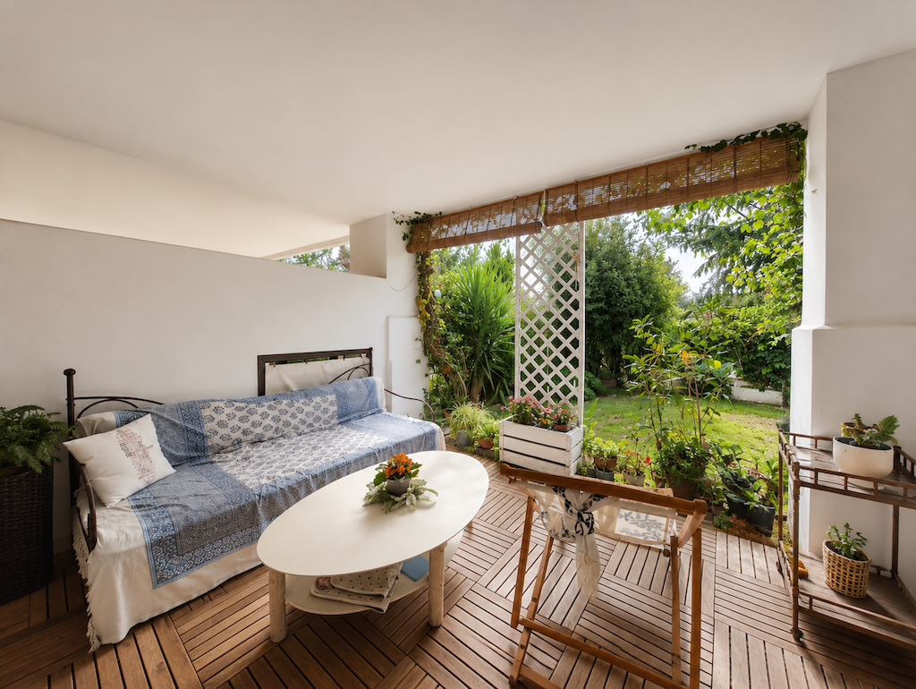 Covered terrace with sofa and garden access