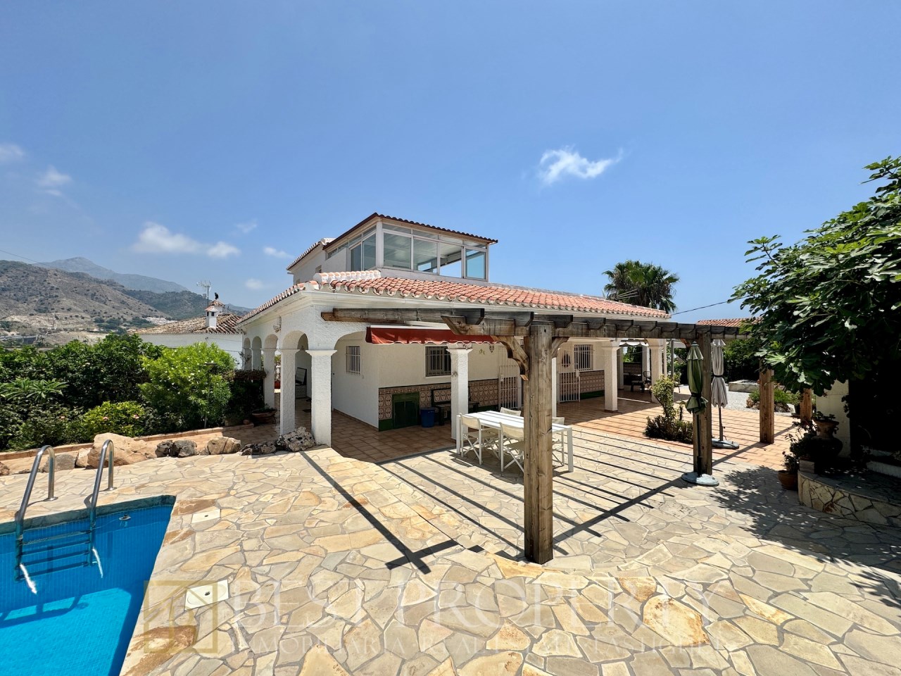 Covered terrace by the pool with outdoor dining area
