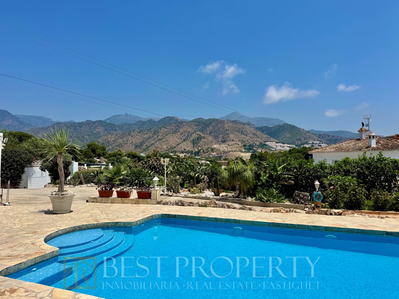 Large outdoor pool with garden and mountains in background