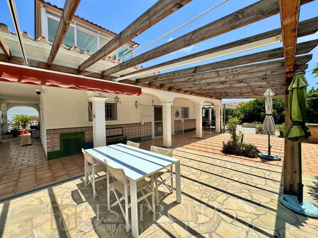 Covered terrace with dining table and shade