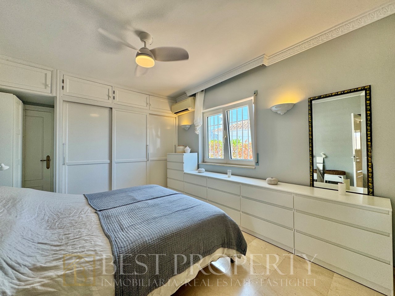 Main bedroom with built-in wardrobes and white dresser