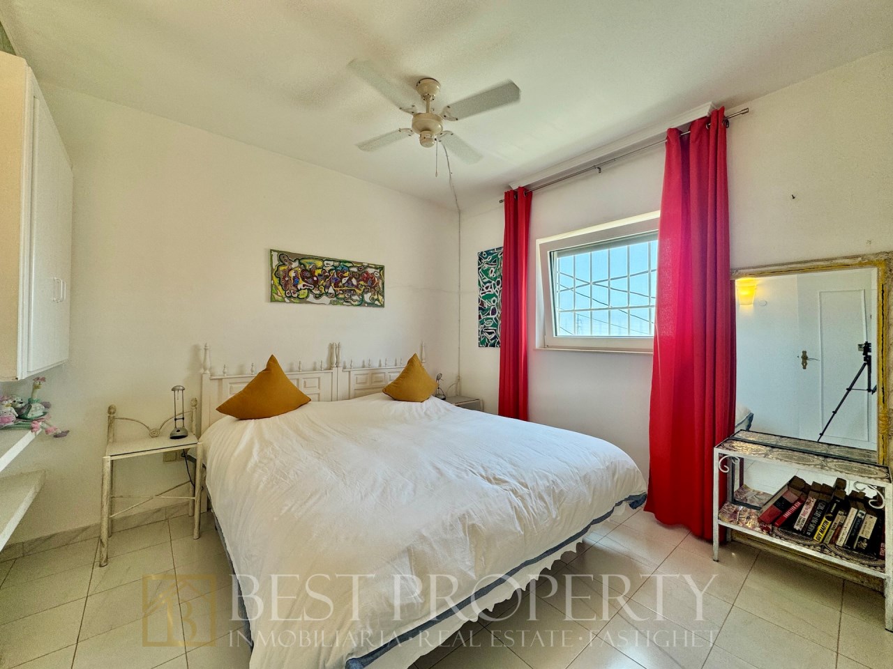 Double bedroom with large bed and red curtains