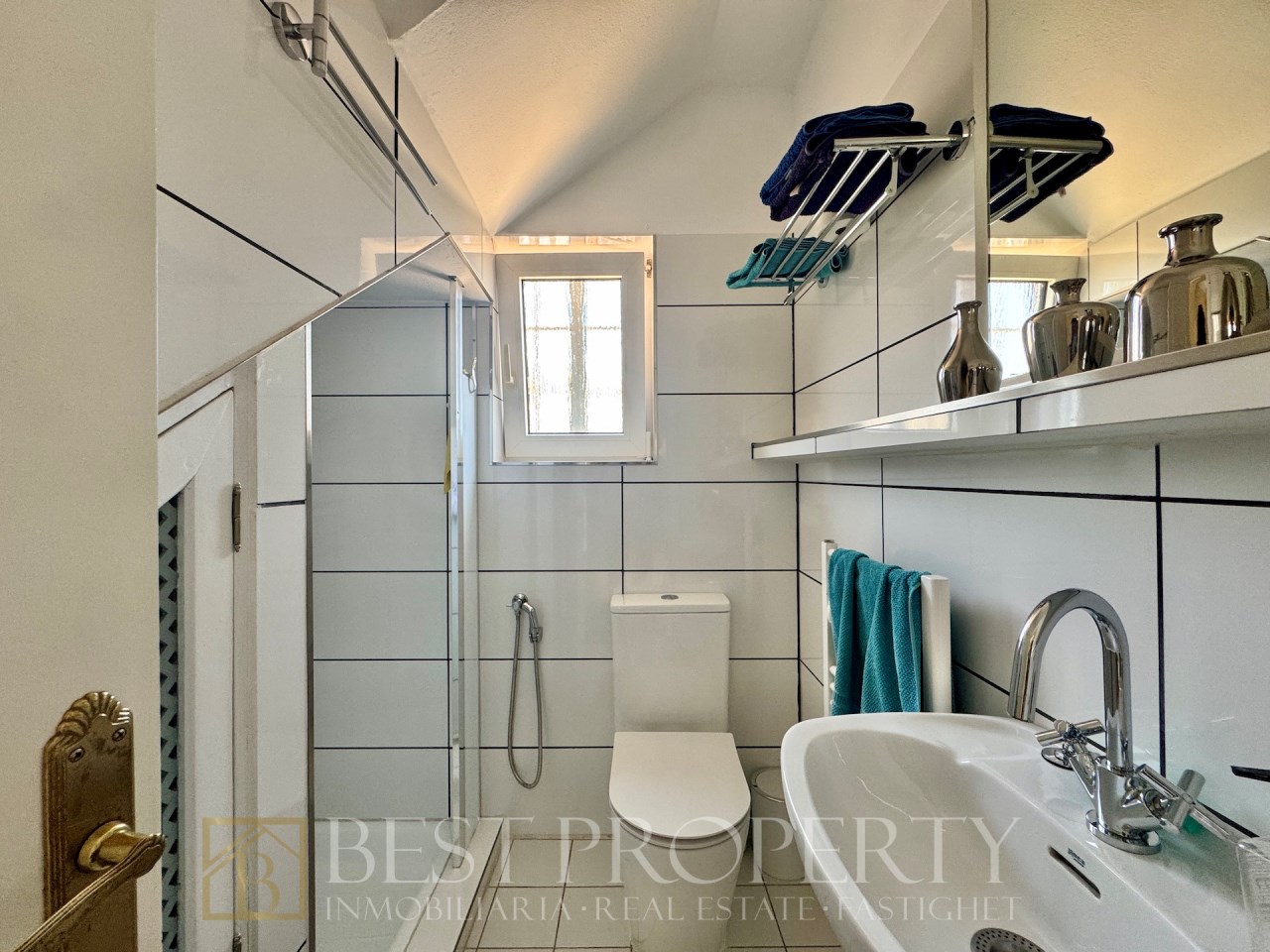 Small bathroom with shower, sink and white tiles