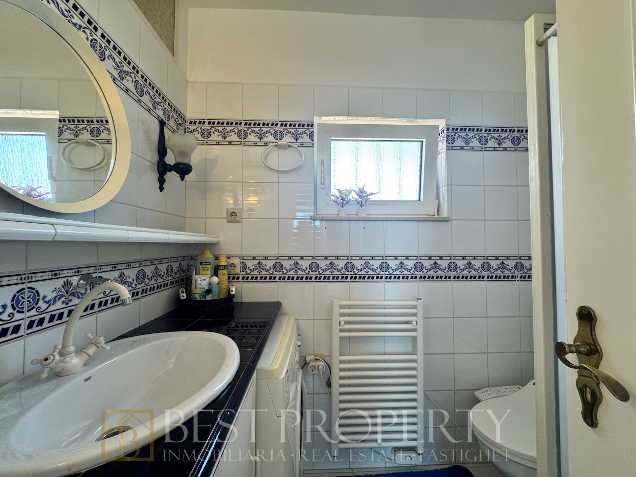 Compact bathroom with round sink and blue details