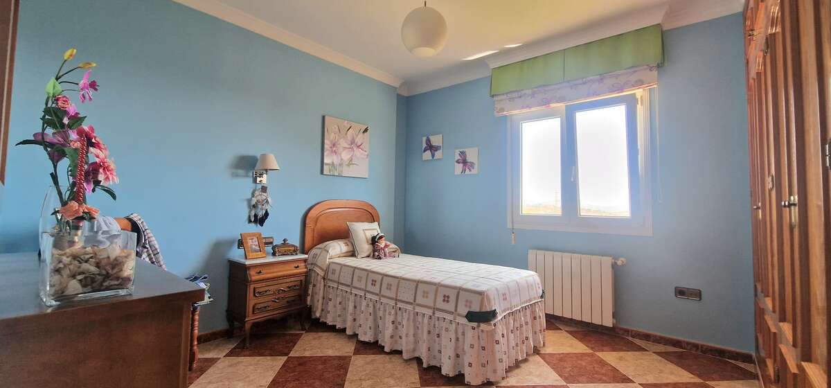 Blue single bedroom with bed and wardrobes