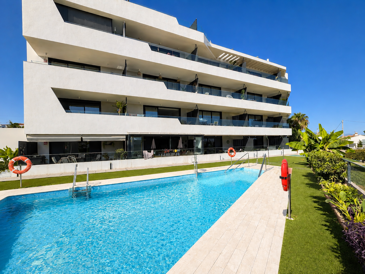 Outdoor pool with modern building and landscaped areas