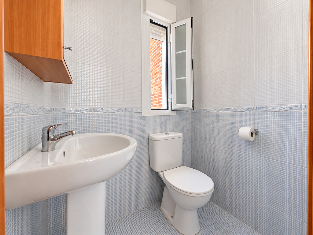 Small toilet room with sink and toilet