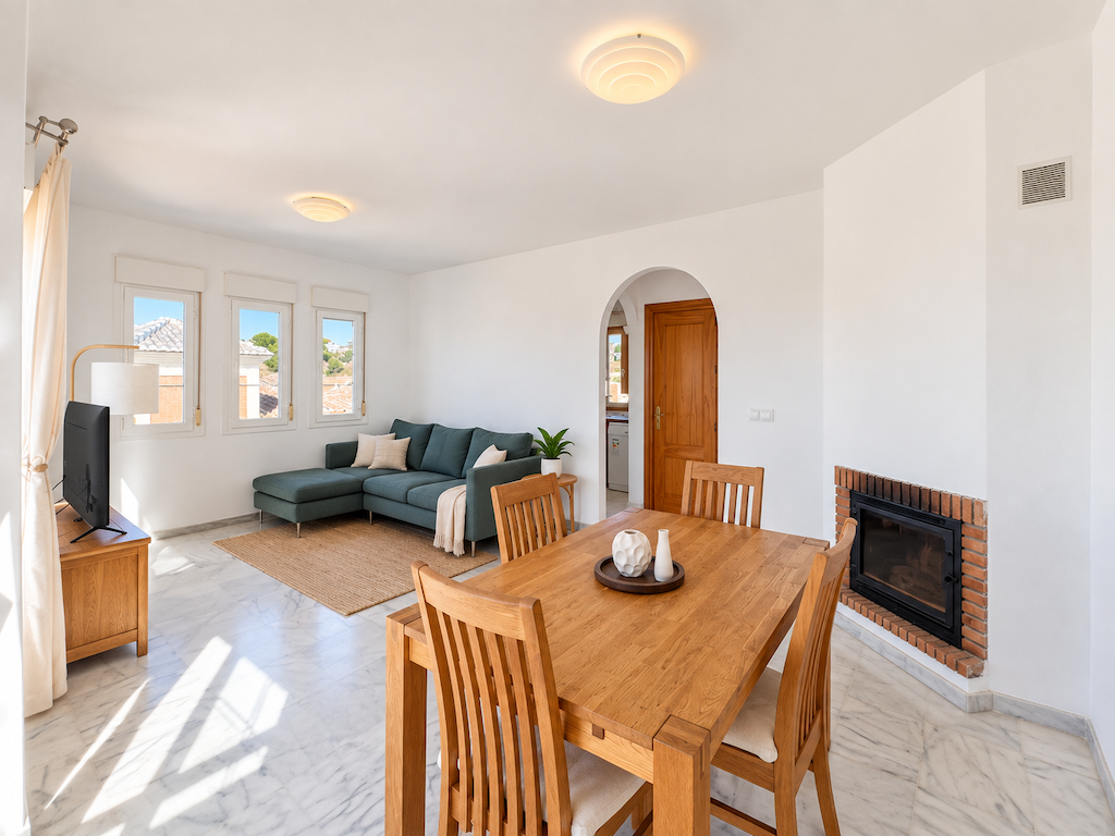 Living room with sofa, fireplace and integrated dining area