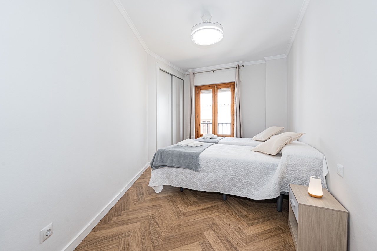 Bright twin bedroom with built-in wardrobe and exterior window