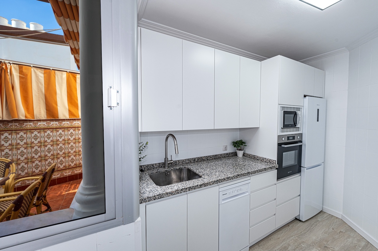 White kitchen with access to outdoor terrace