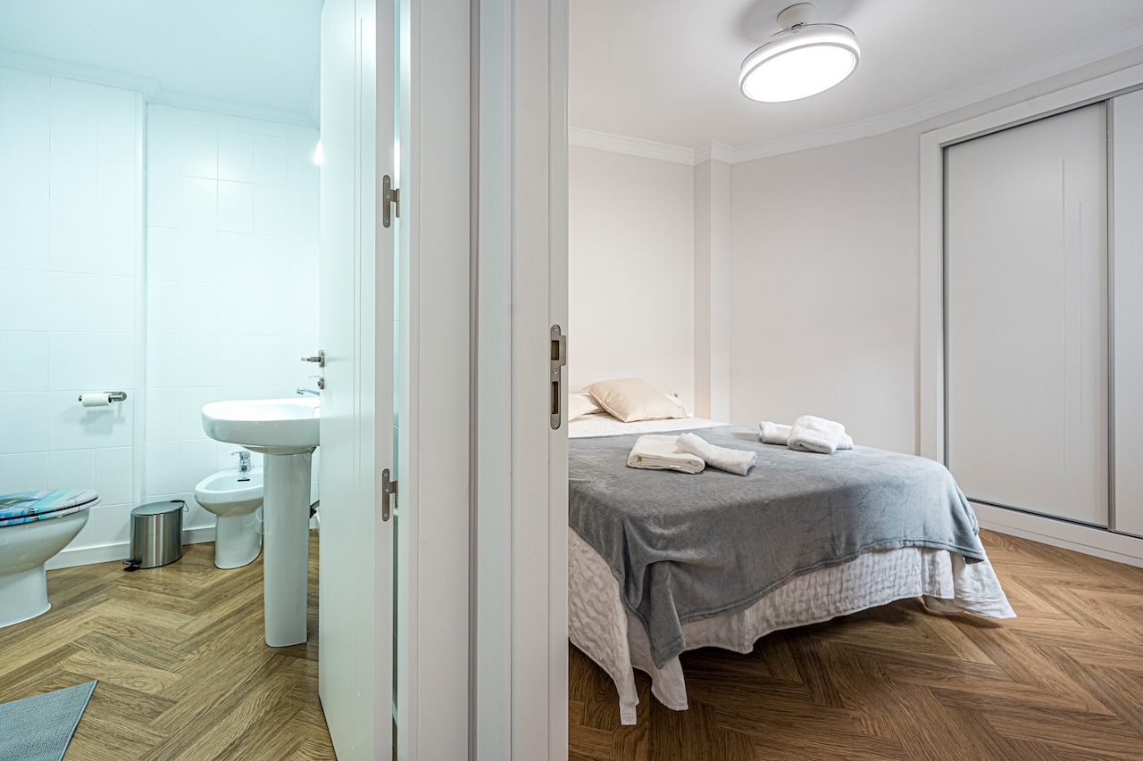Bathroom with shower, sink and bedroom access