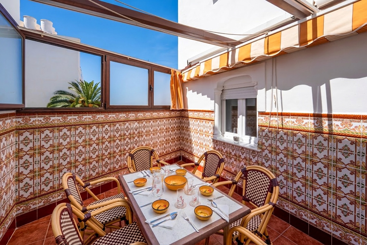 Sunny covered terrace with dining table