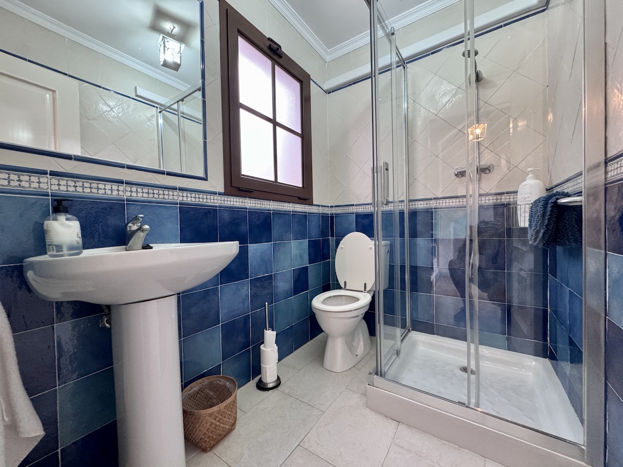Bathroom with shower and blue tiles