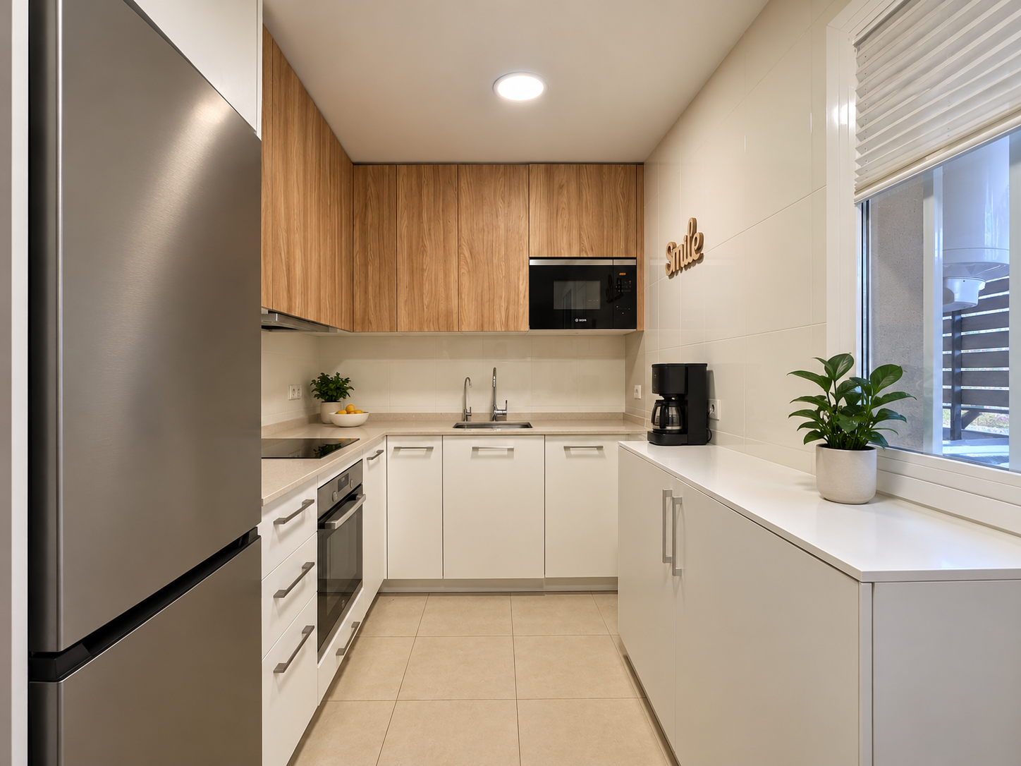 Narrow kitchen with white cabinetry and built-in appliances