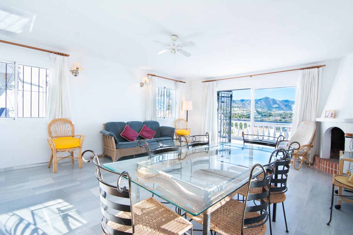 Bright dining room with glass table and views