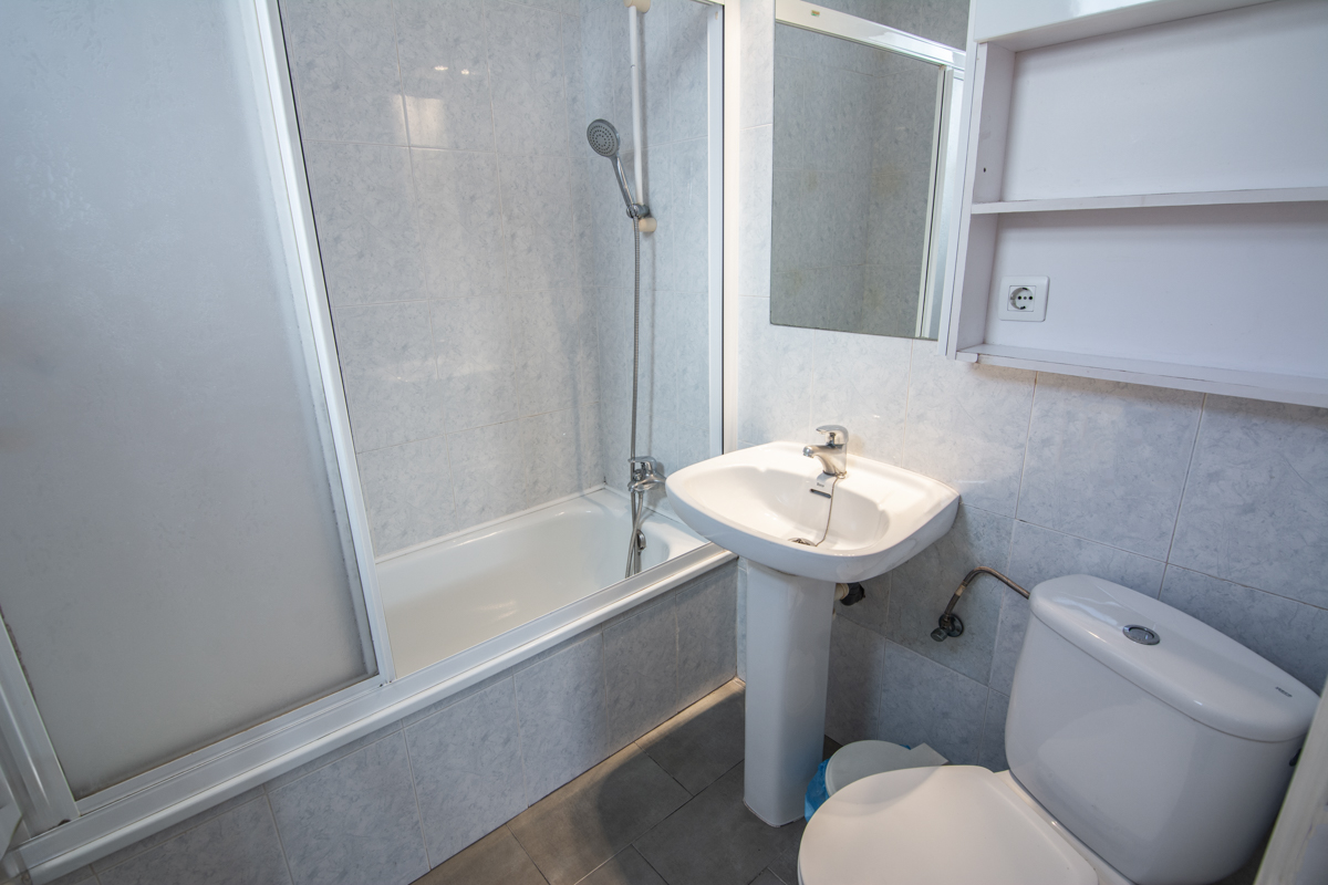 Bathroom with bathtub, sink and storage shelf