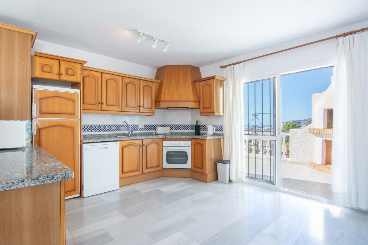 Equipped kitchen with wooden cabinets and exterior access