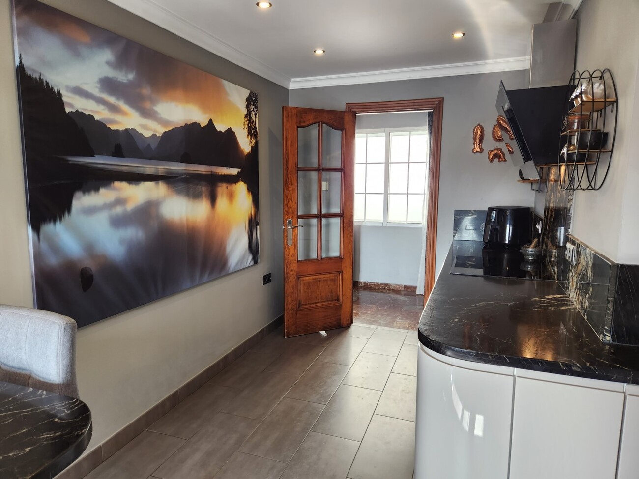 Narrow kitchen with dark countertop and hallway access