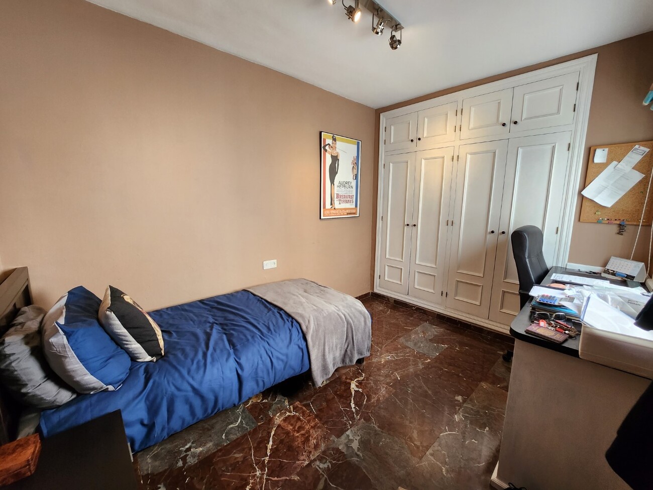 Single bedroom with desk and white wardrobe