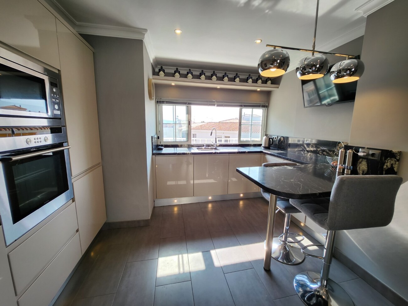 Modern kitchen with integrated appliances and breakfast bar