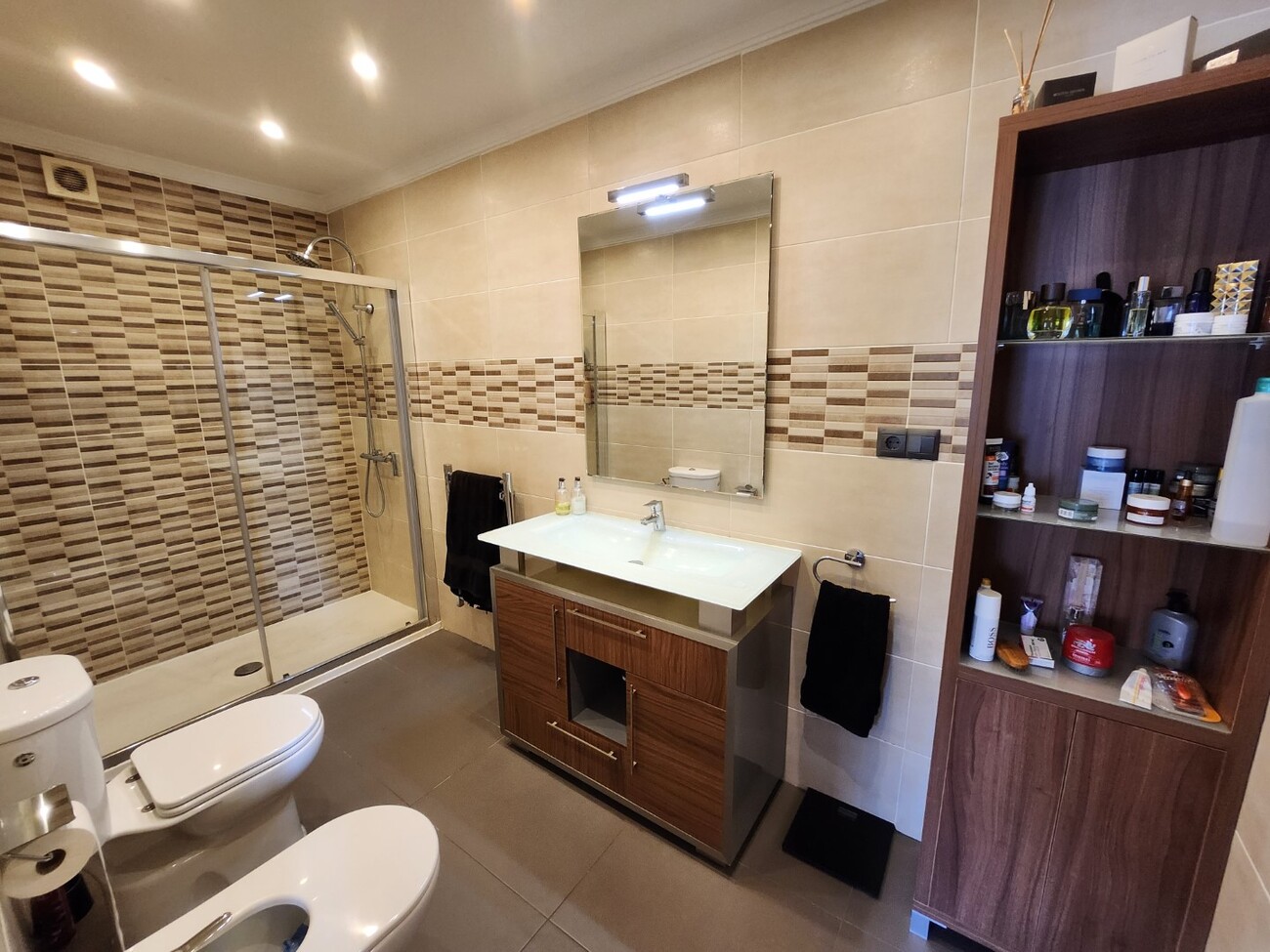 Full bathroom with shower, sink and storage