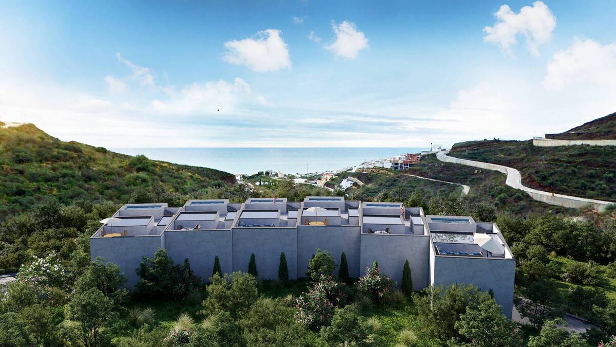 Aerial view of homes with landscape and sea beyond