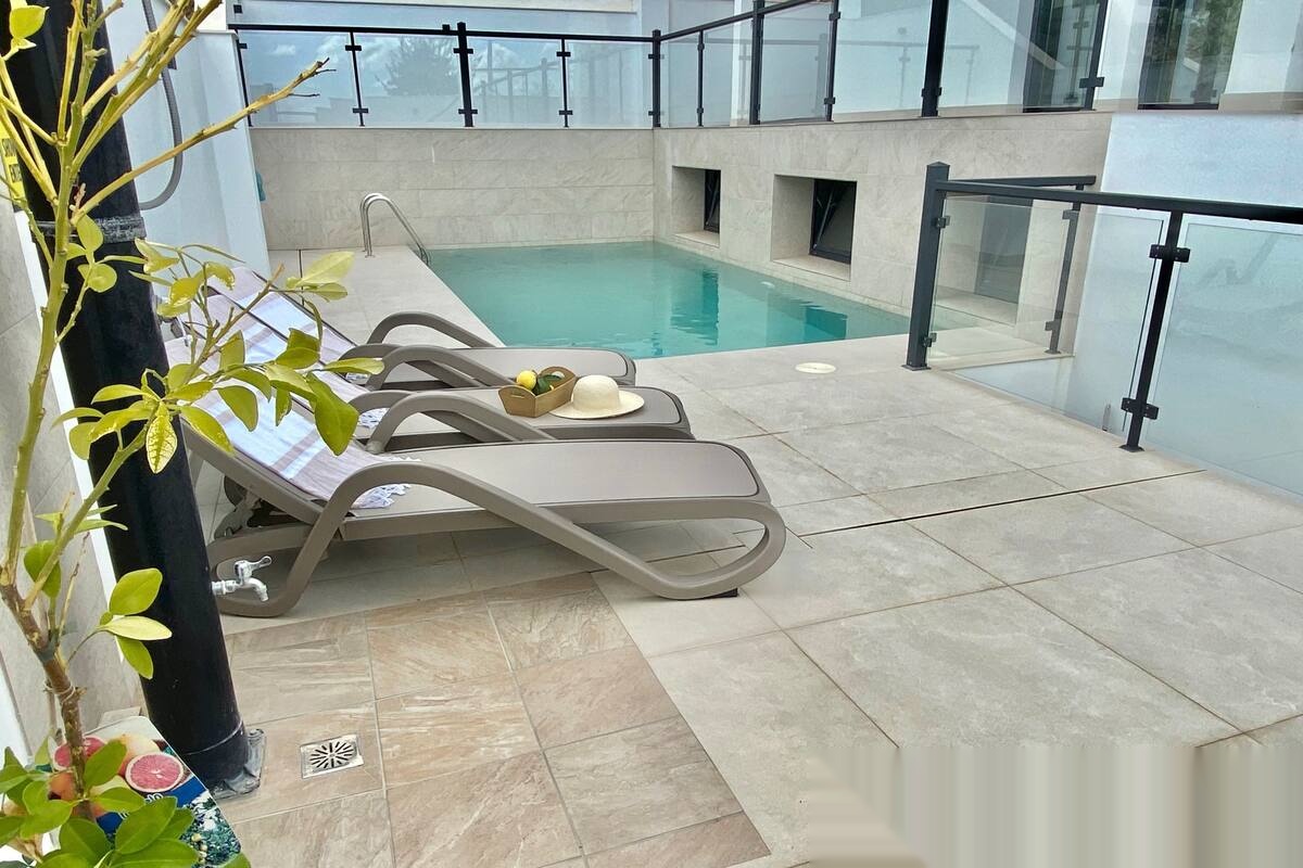 Outdoor pool with loungers and side access