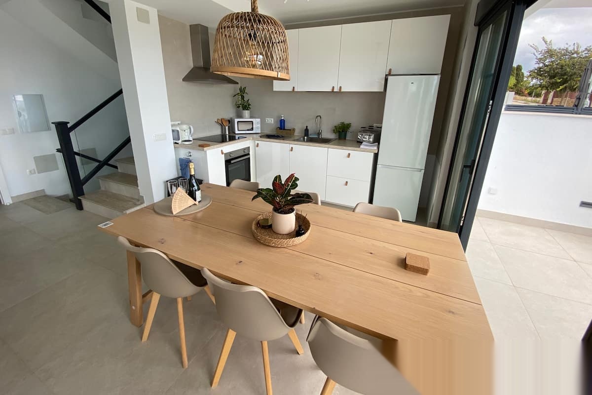 Dining area with wooden table beside open kitchen