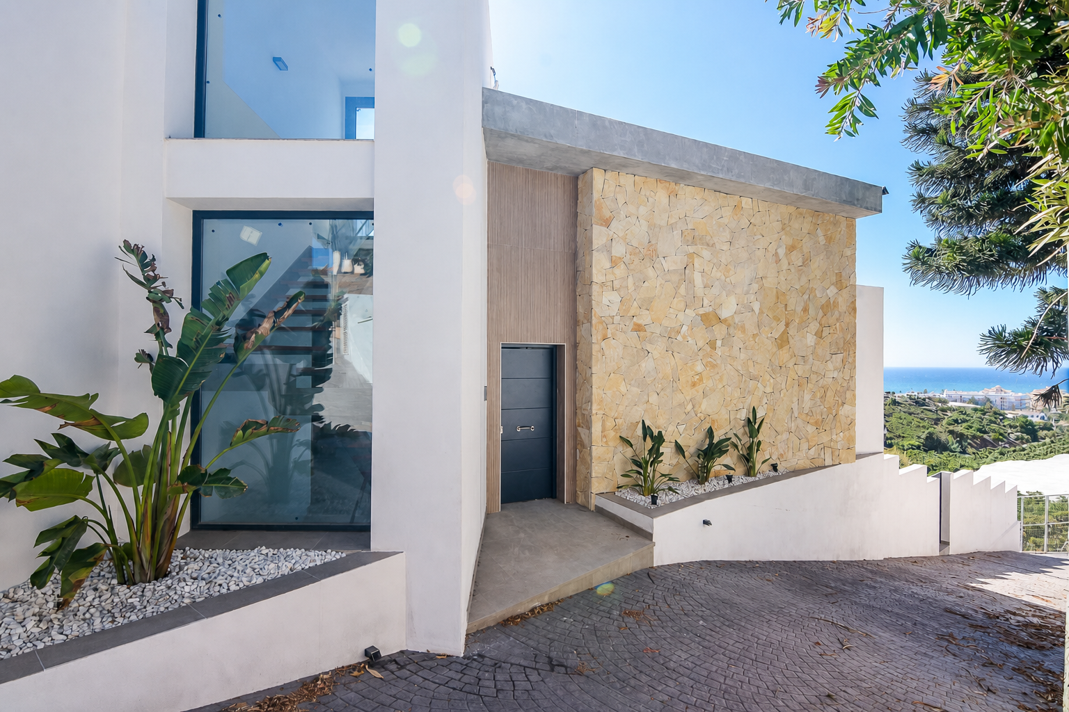 Modern main entrance with sea views and planters
