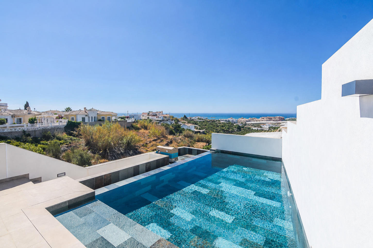 Infinity pool with sea views and coastal surroundings