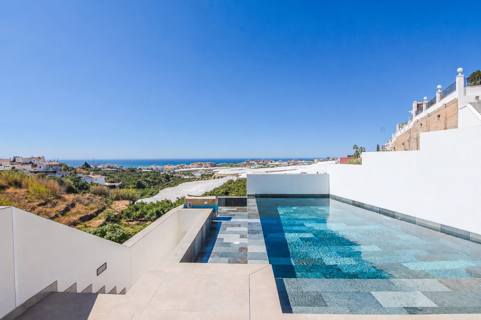 Infinity pool beside the terrace with sea views