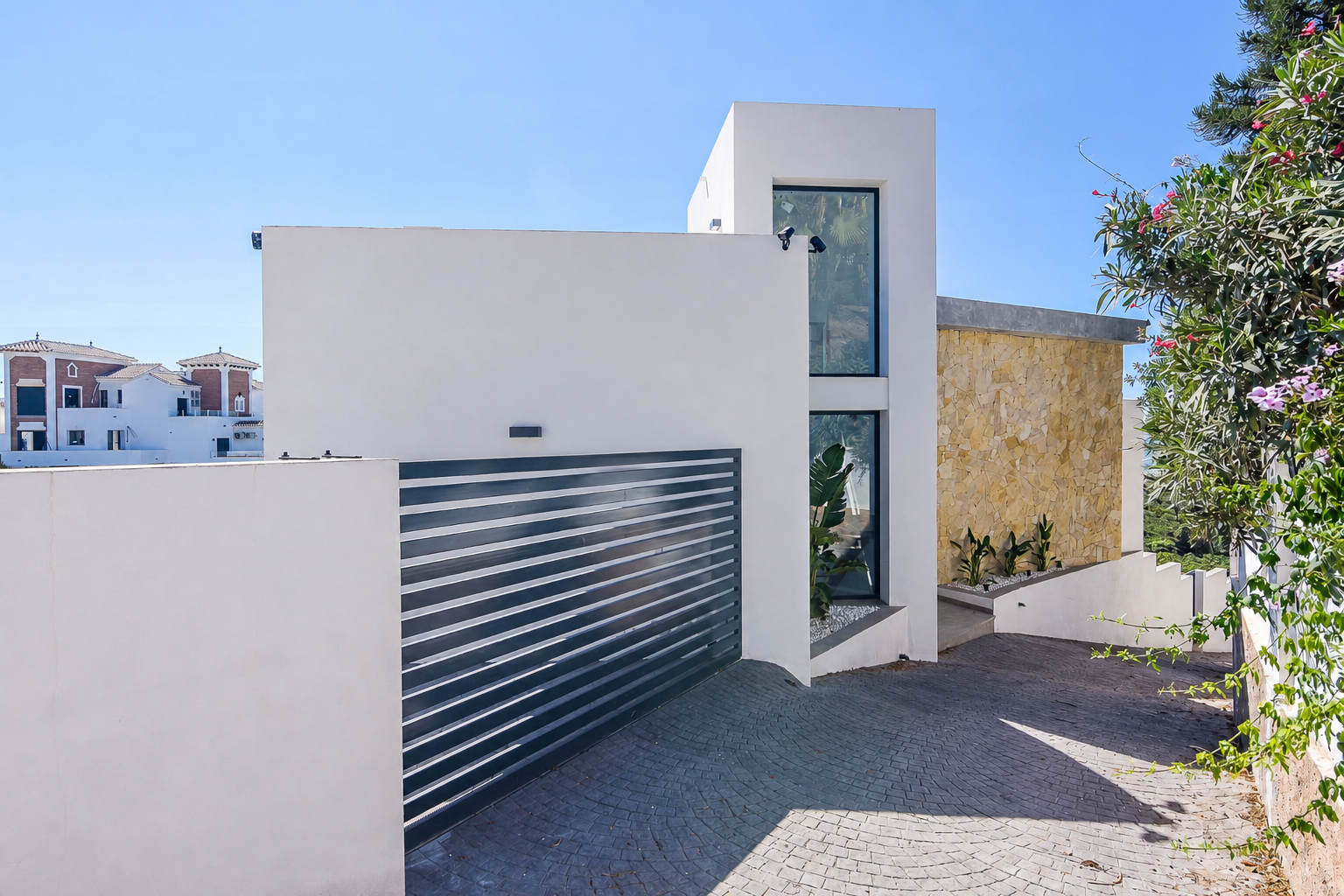 Exterior access with sliding gate and modern facade