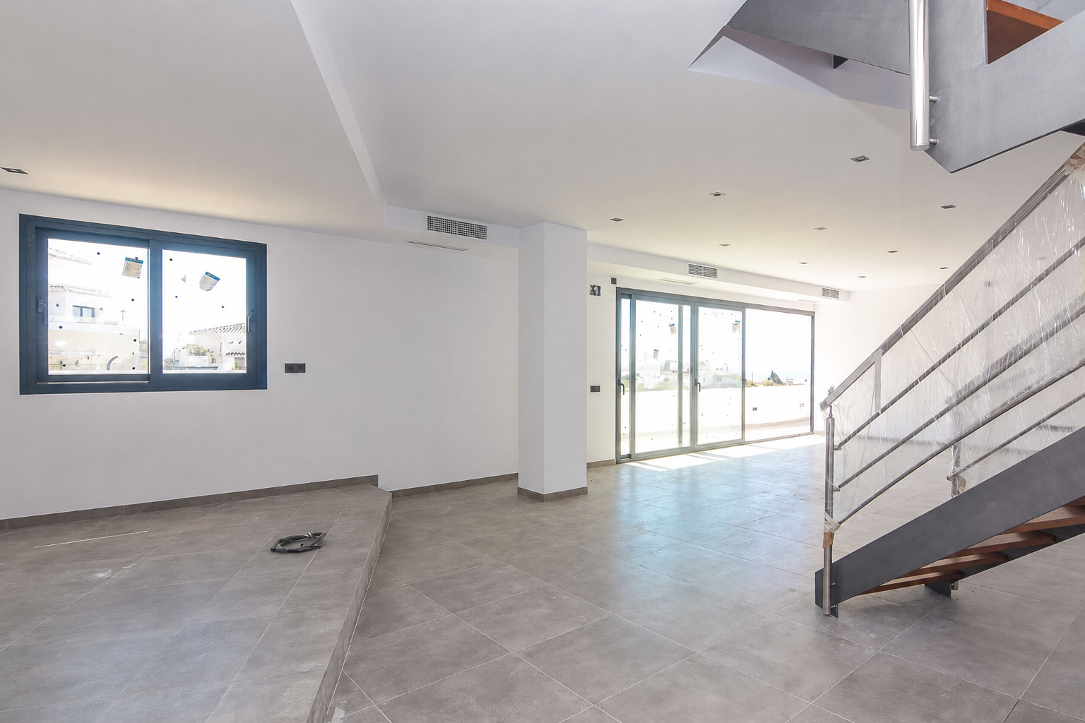 Large open-plan living room with staircase and outdoor access