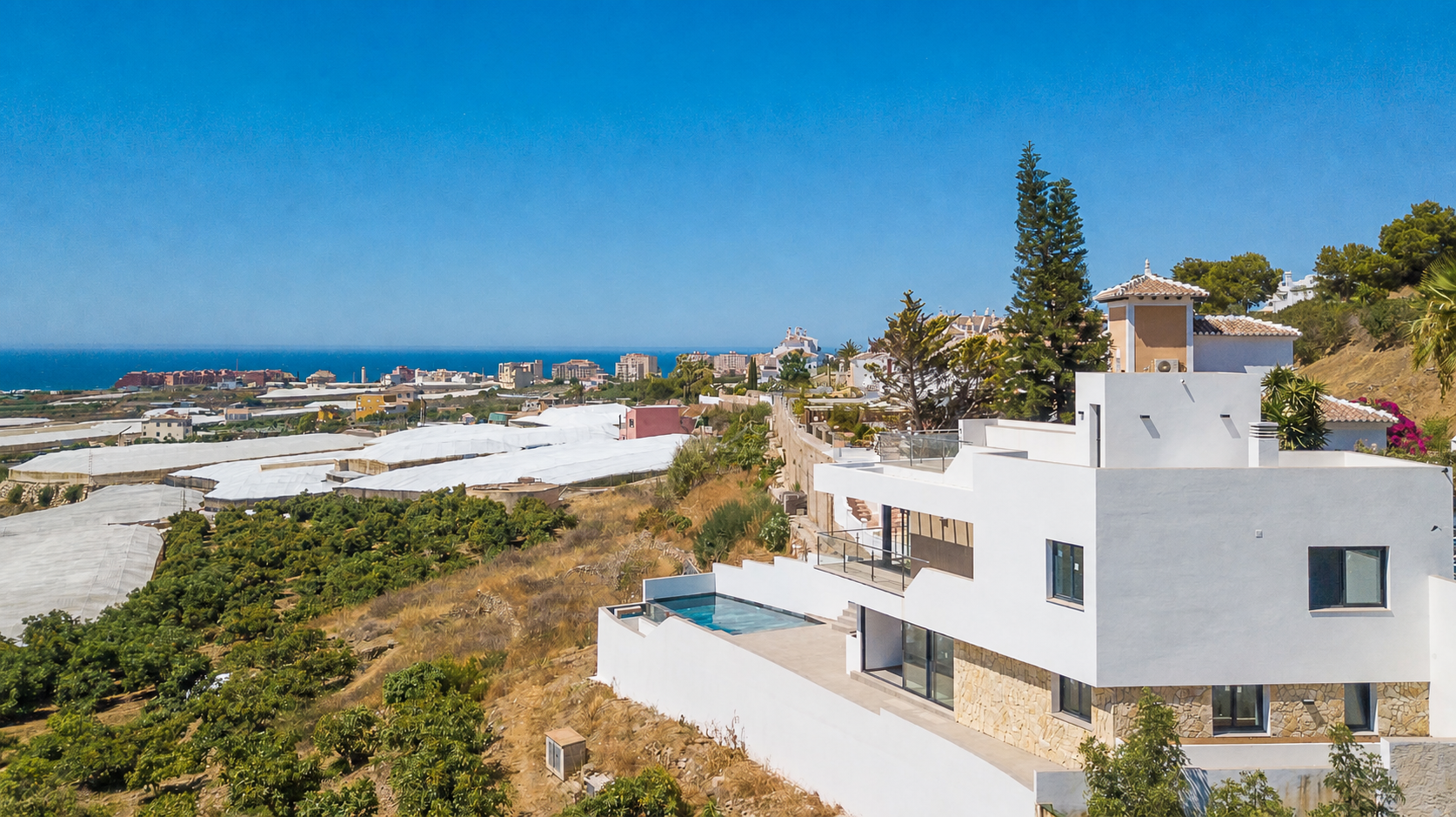 Exterior view of the house with pool and white facades